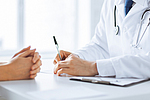 Arzt macht sich Notizen währen eines Patientengesprächs