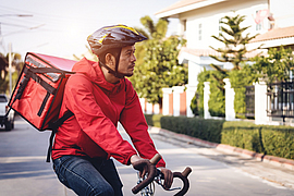 Kurier auf einem Fahrrad, der Lebensmittel in der Stadt ausliefert