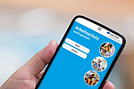 Smartphone mit ASD APP vor verschwommenem Hintergrund