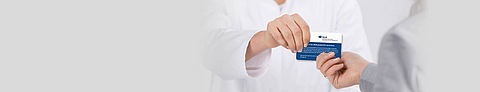 Patientin überreicht Versicherungskarte der BGN.