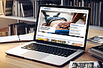 Ein Laptop auf einem Schreibtisch in einem Büro zeigt die Startseite des BGN-Webmagazins Akzente